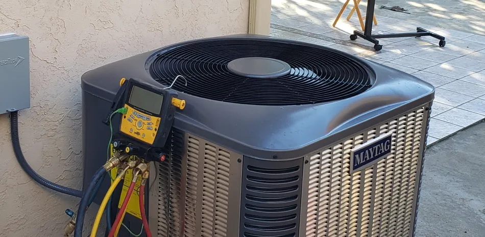 hire right hvac contractor A gray Maytag AC unit is connected to yellow, red, and blue hoses with gauges in an outdoor setting.